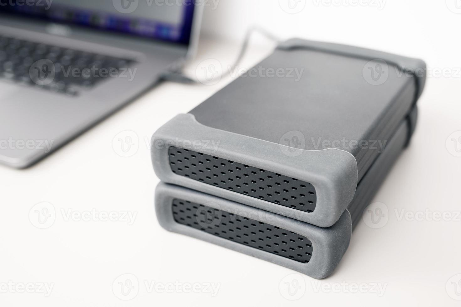 Close up of External hard drives storage connected to a modern laptop computer photo