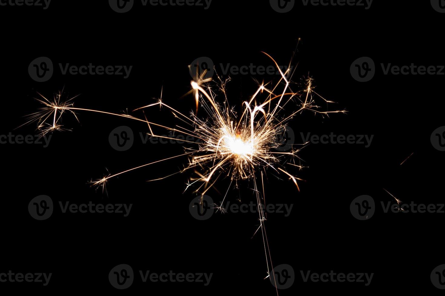 Burning sparkler isolated on black background. Fireworks theme. Light effect and texture. photo