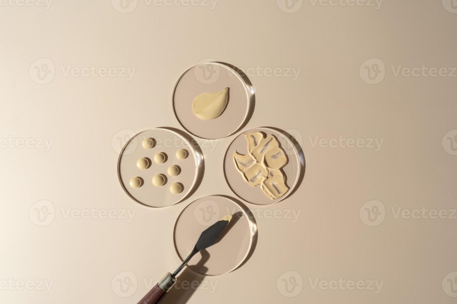 Face tonal cream smudge and drops lying on glass plates. Cosmetology and makeup concept photo