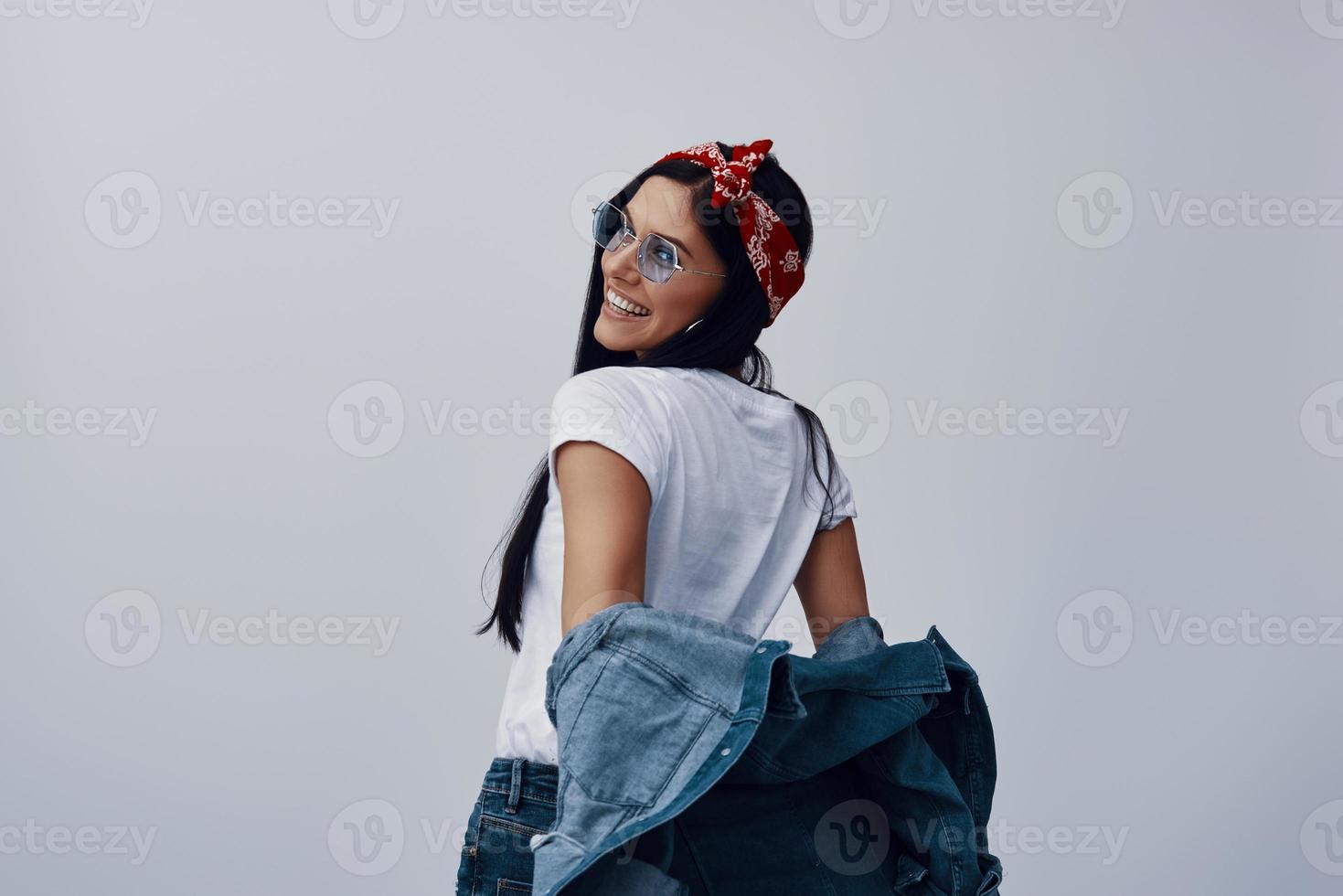 Fashionable young woman in bandana looking away and smiling photo