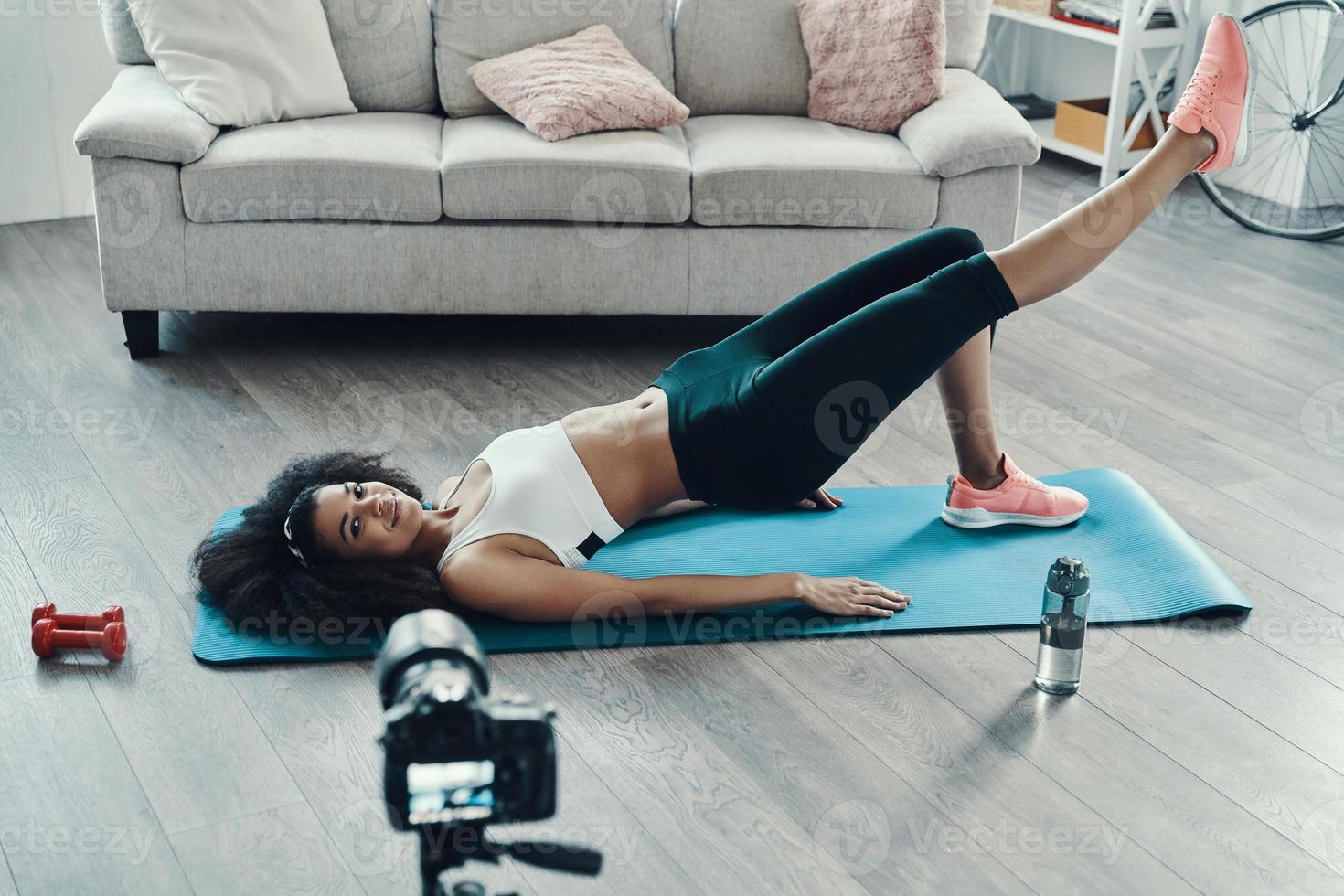 Top view of young fit African woman working out and smiling while making social video photo