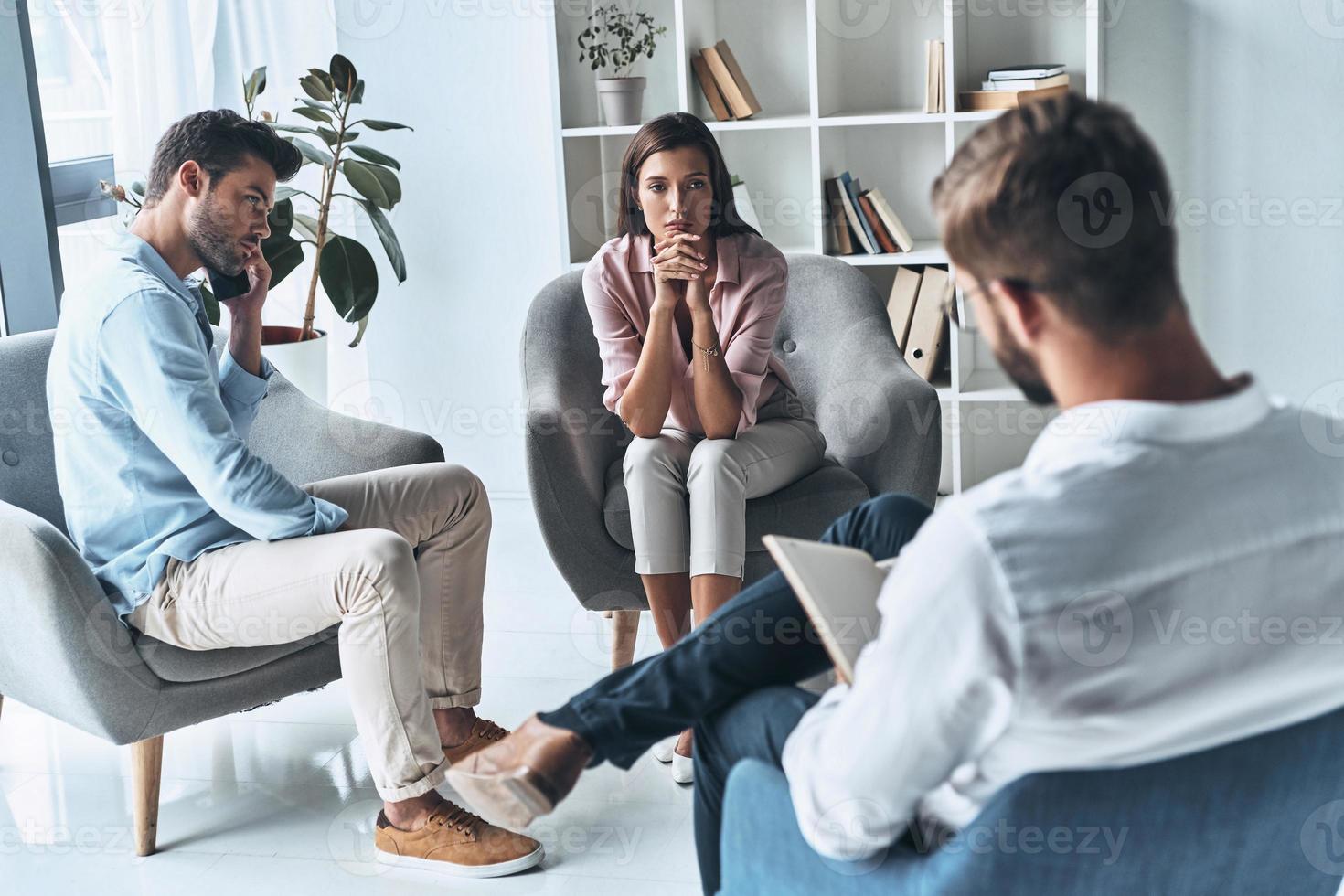 Almost divorced. Young married couple talking while sitting on the therapy session with psychologist photo