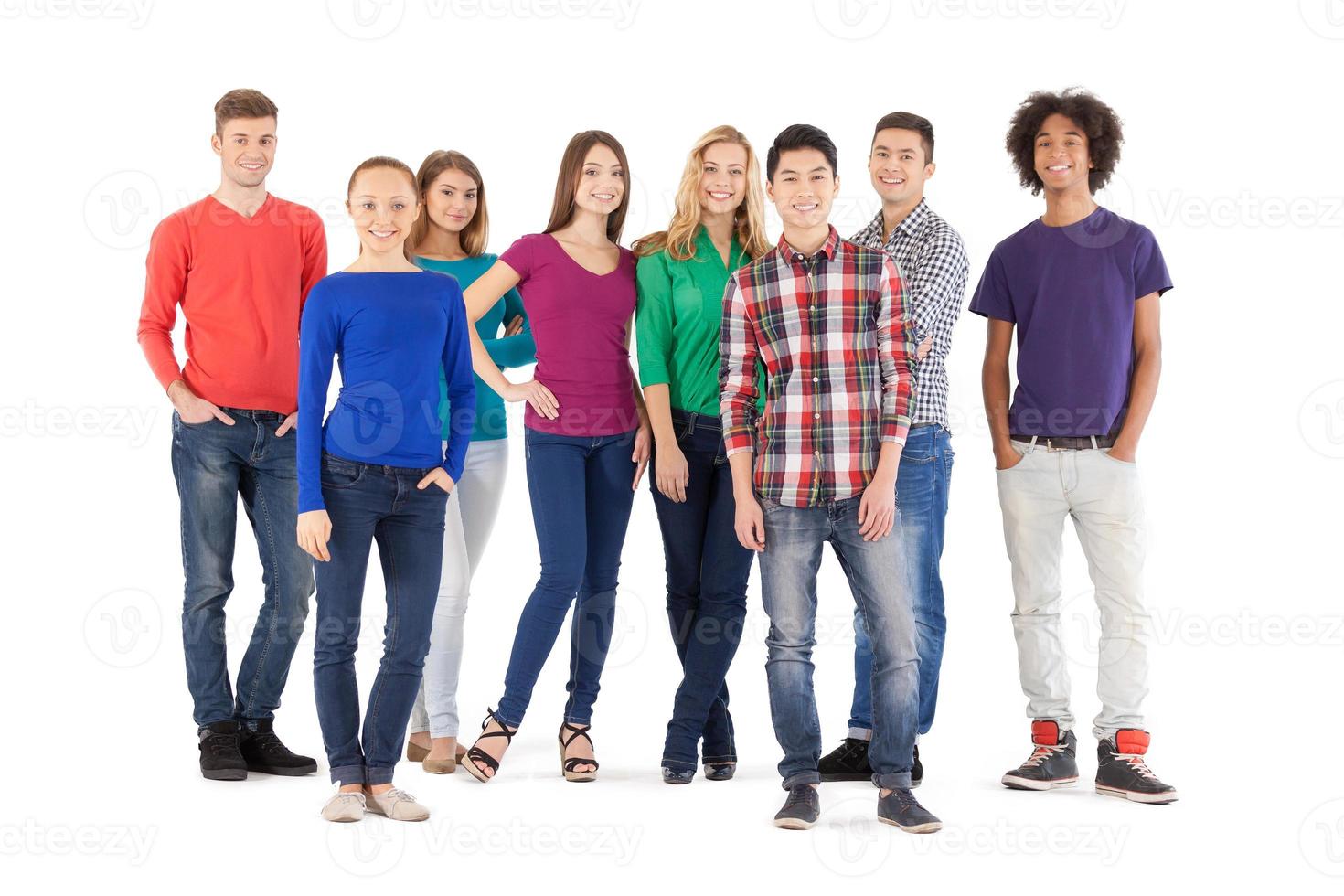 Casual people. Full length of cheerful young people smiling at camera while standing isolated on white photo