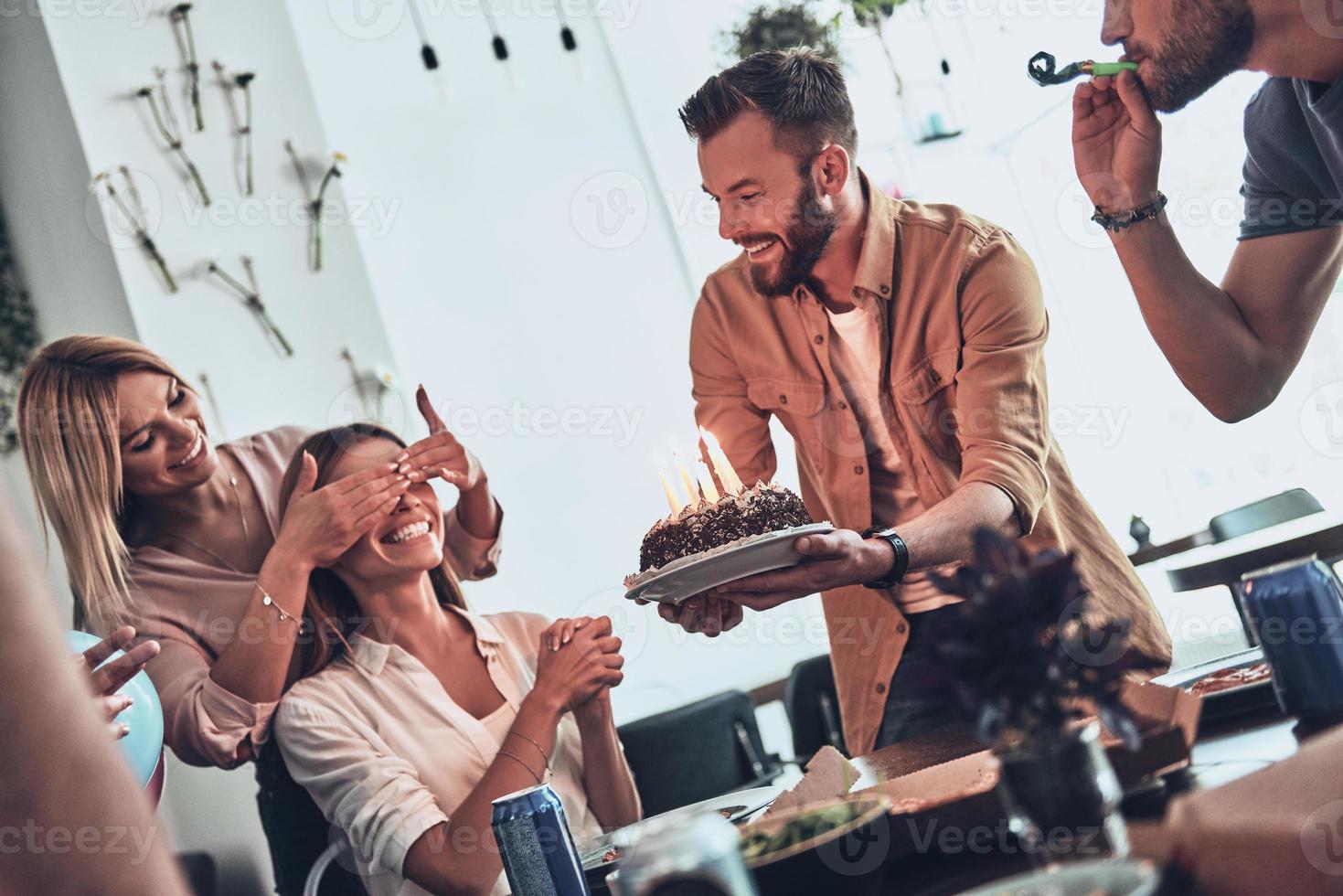 nuestra cumpleañera. grupo de personas felices celebrando cumpleaños entre amigos y sonriendo mientras disfrutan de una fiesta foto