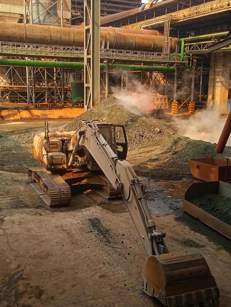 an excavator parked at the mining site, both used to transport and lift various kinds of heavy tools or materials photo