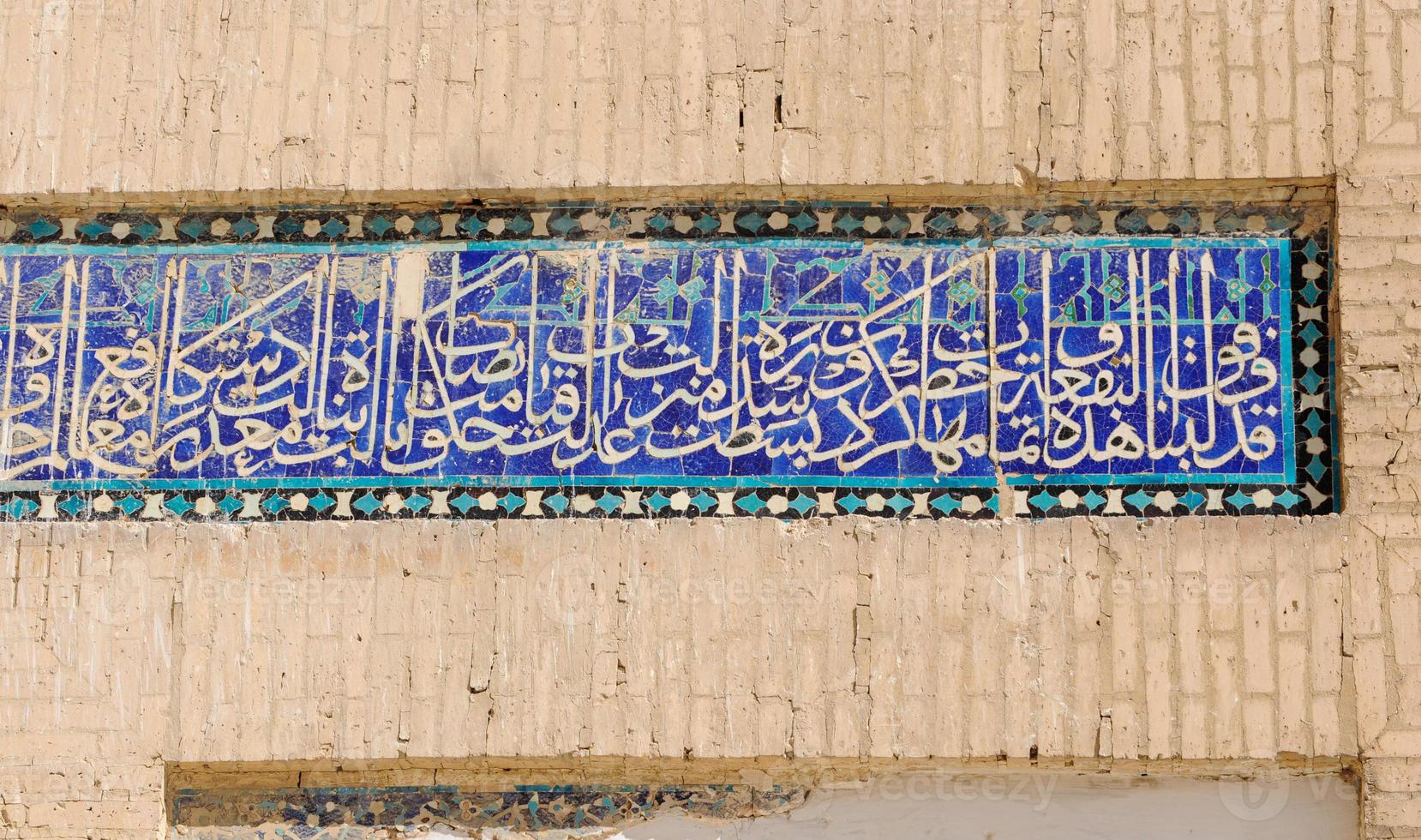 A closeup of a wall of an old building with design and foreign characters photo