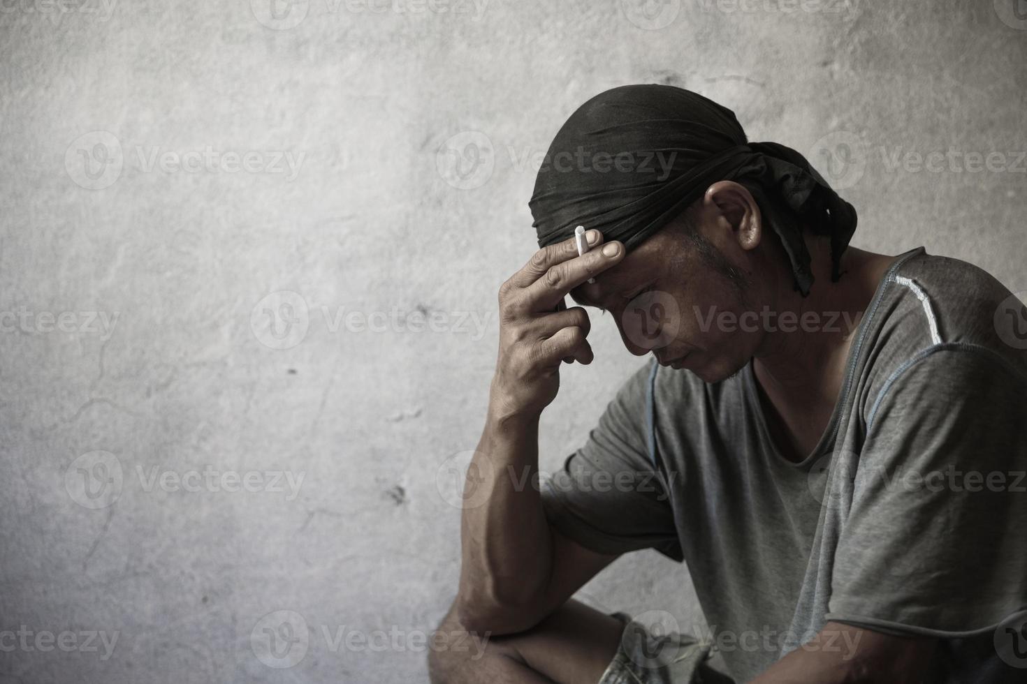 Men who show stress and loneliness, Homeless man drug  addict sitting alone and depressed  at an abandoned house feeling anxious and lonely, social documentary concept, Copy space photo