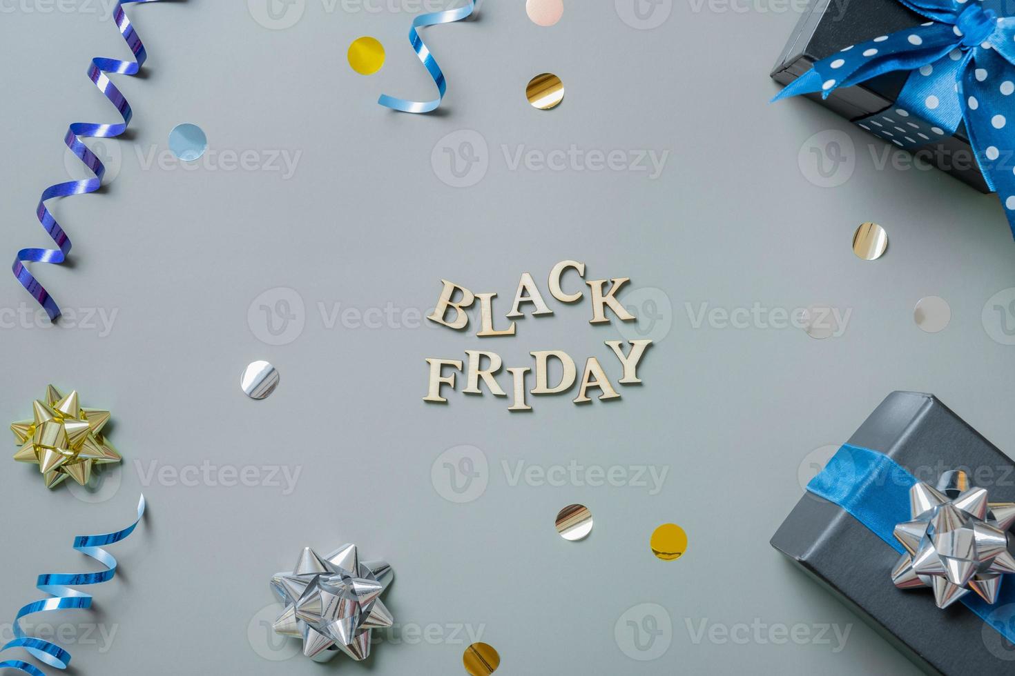 Black friday text with gifts and festive tinsel flat lay photo