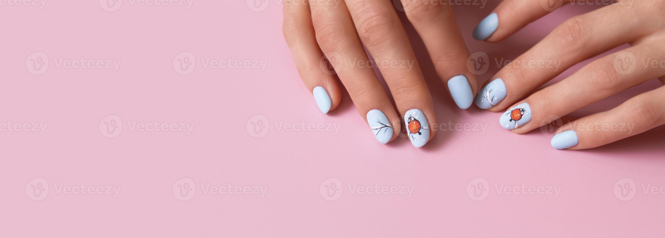 Banner with female hands with winter snow manicure with stickers under a matte top on pink background photo