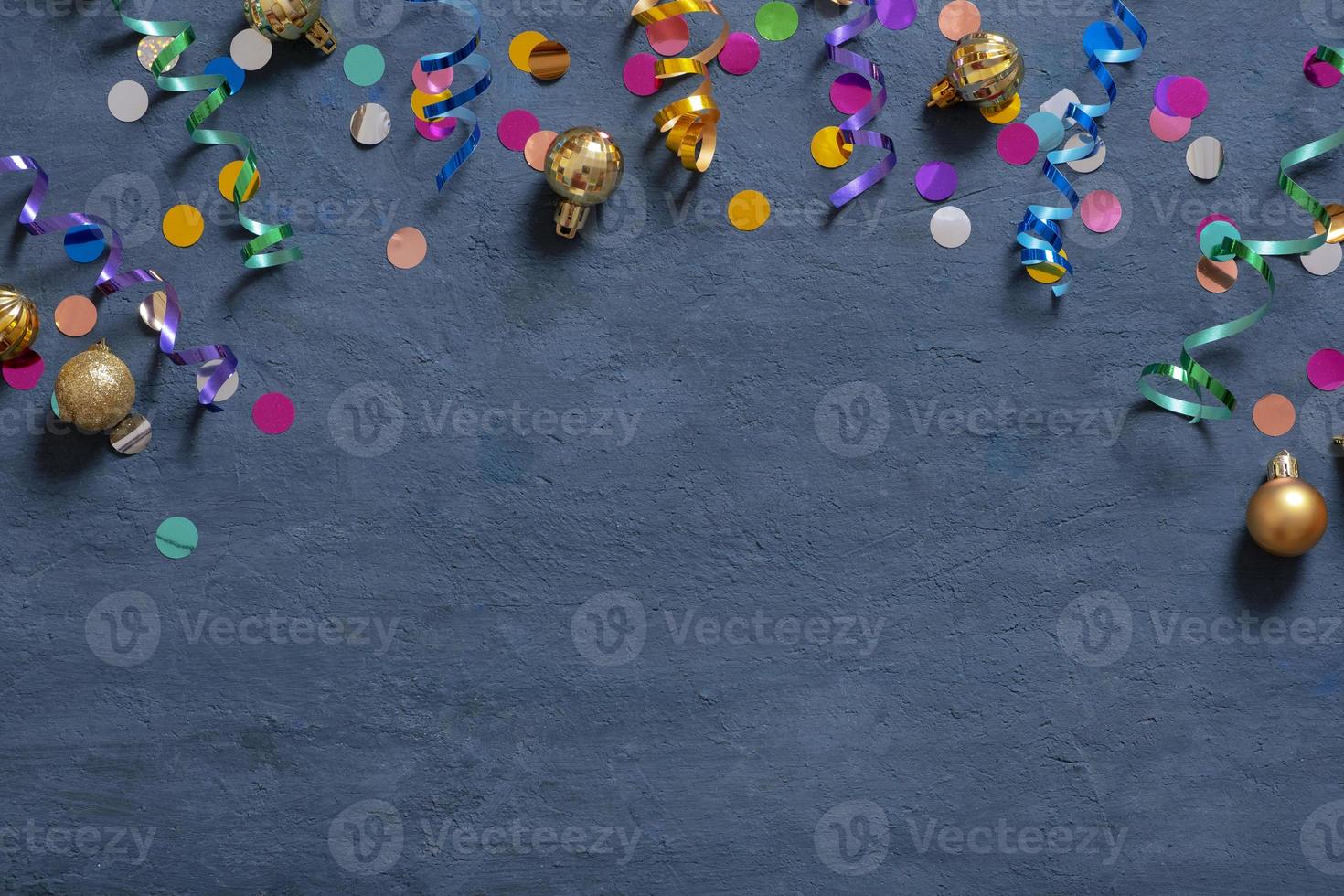 Colorful tinsel and Christmas decorations on a dark cement background with copy space photo