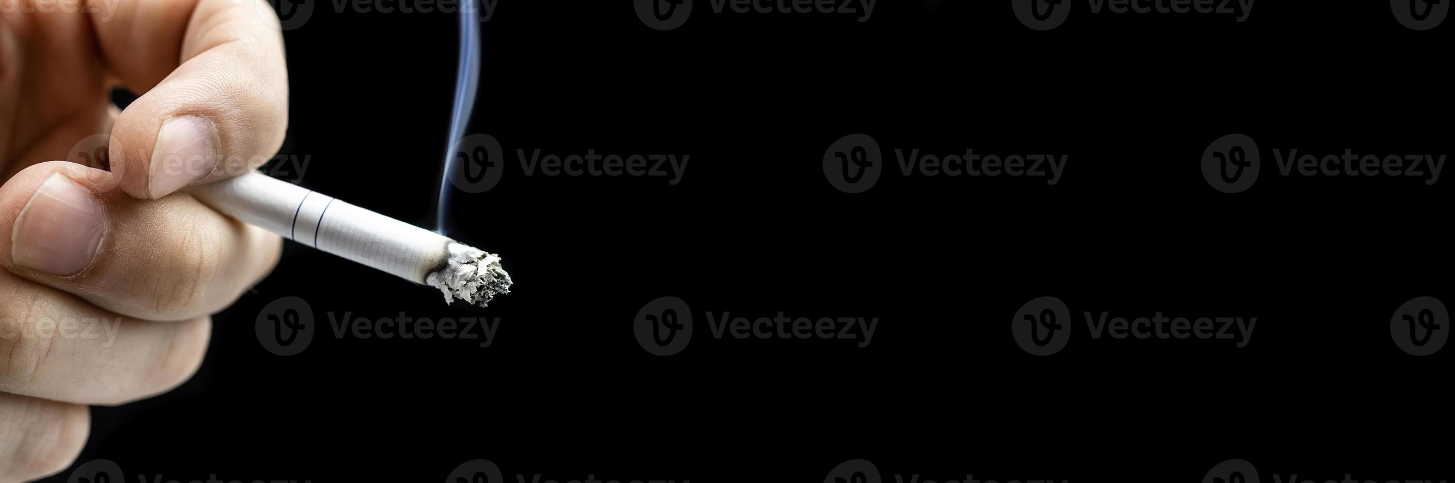 Cigarette hand black background photo