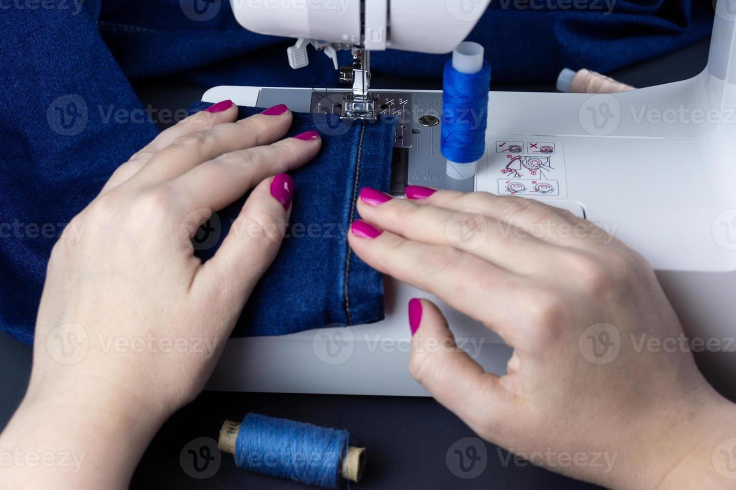 manos en la maquina de coser foto