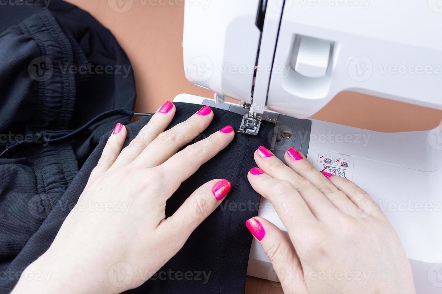 Hands on the sewing machine photo