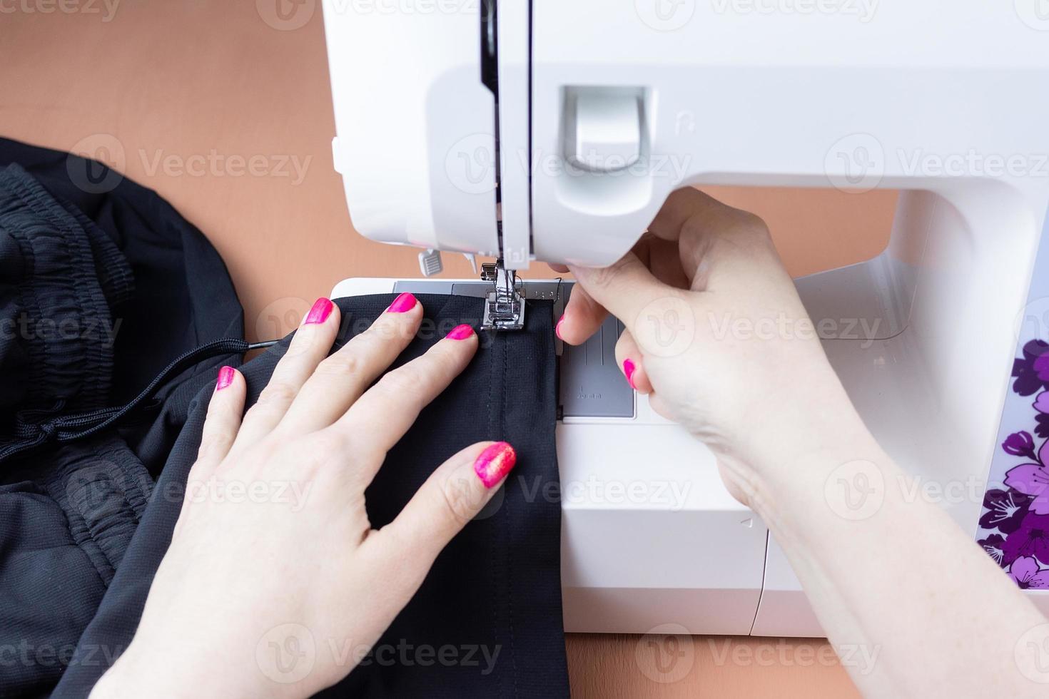 Hands on the sewing machine photo