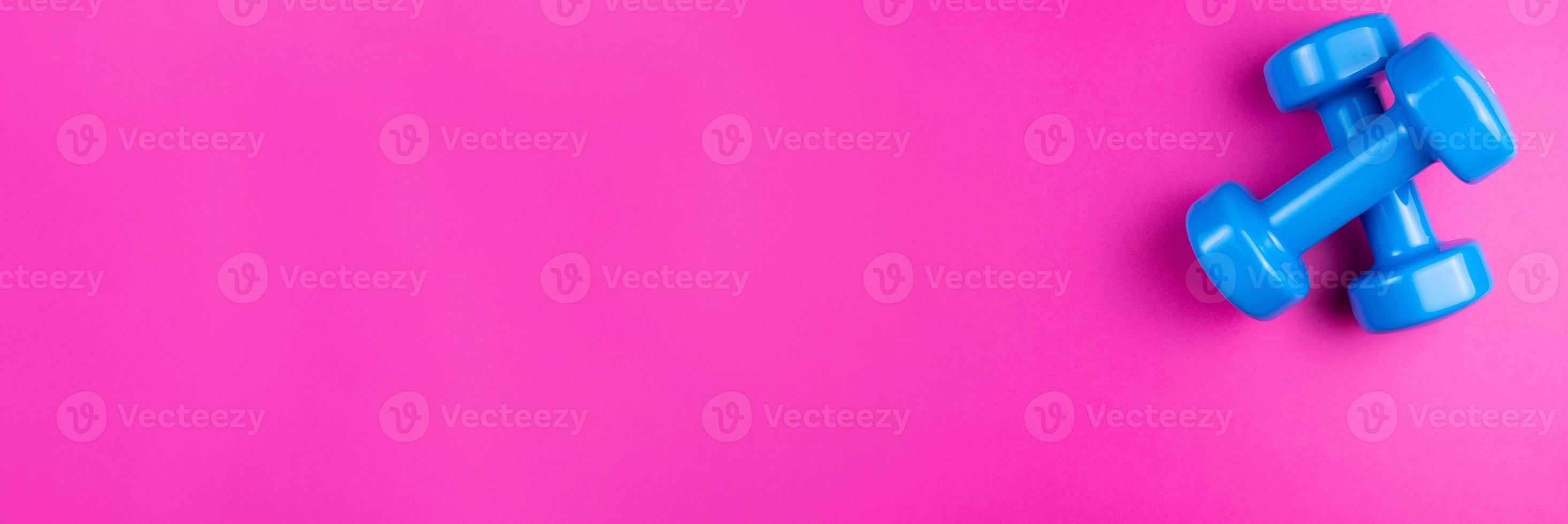 dumbbells on a pink background photo