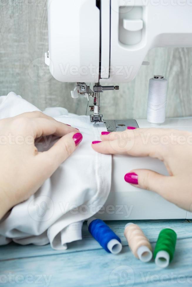 Hands on the sewing machine photo