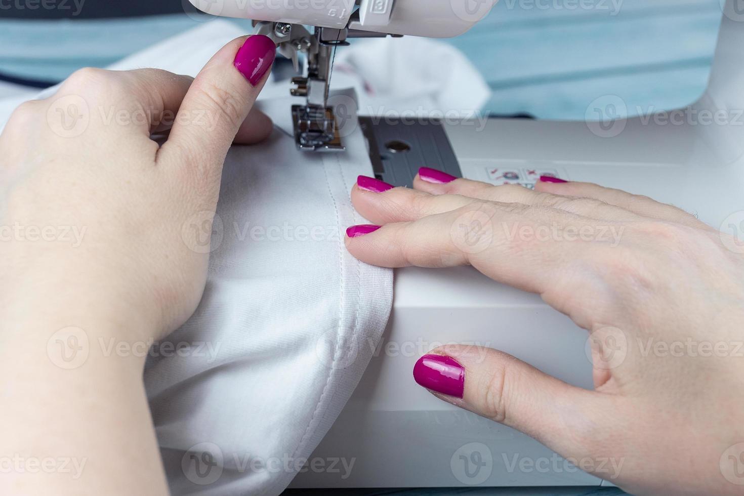 Hands on the sewing machine photo