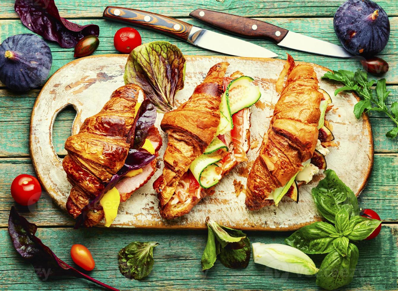 Fresh croissant with meat and fish photo