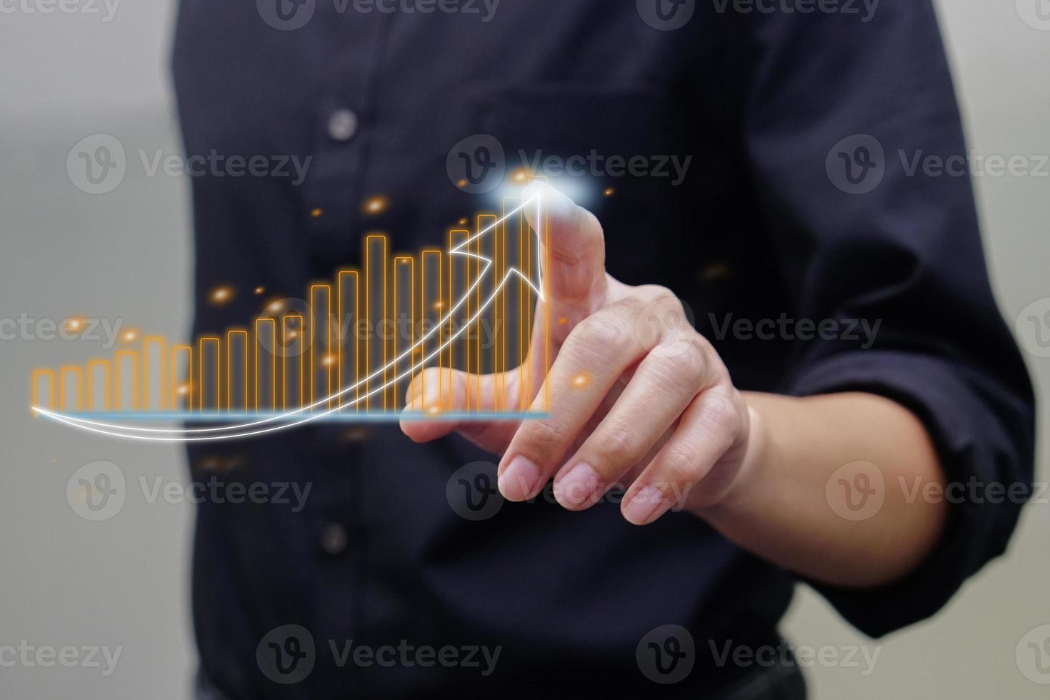 Close up of hand touching on virtual glowing business chart hologram on blurred background. Market and analytics concept. photo