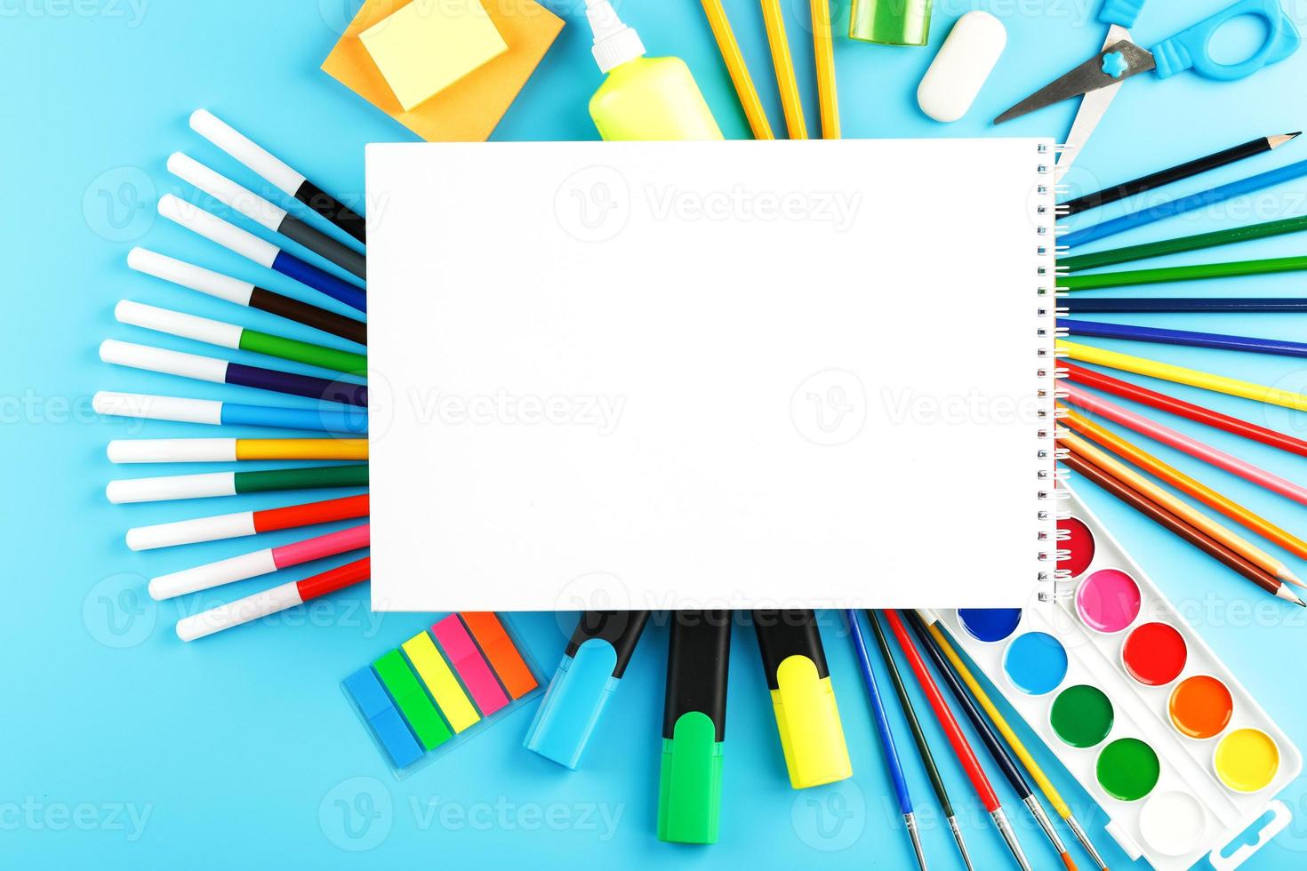 un conjunto de útiles escolares para el aprendizaje y el desarrollo creativo sobre un fondo azul. foto