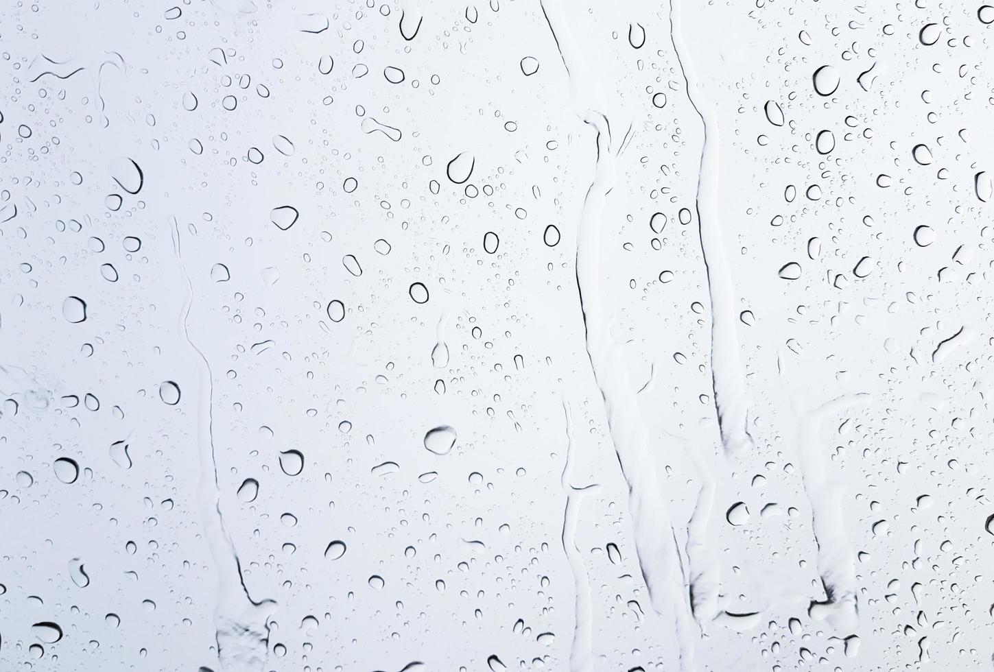 gotas de lluvia blanca sobre el coche de cristal para la textura y el fondo foto