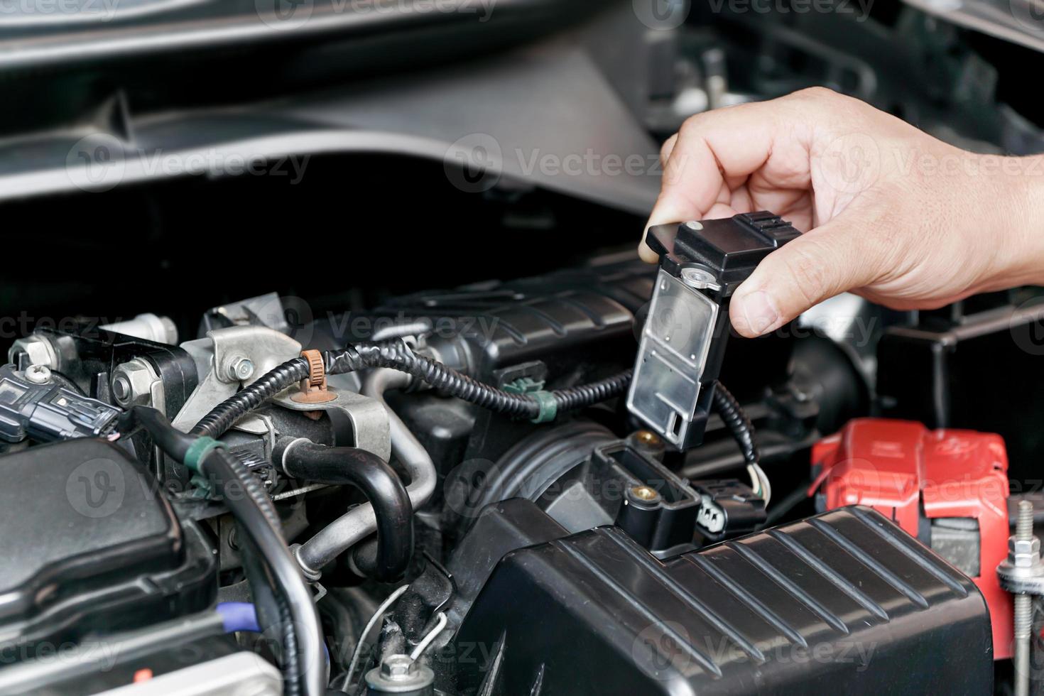 Close up hand a Technician remove airflow sensor in the engine room car for check and cleaning in service concept photo