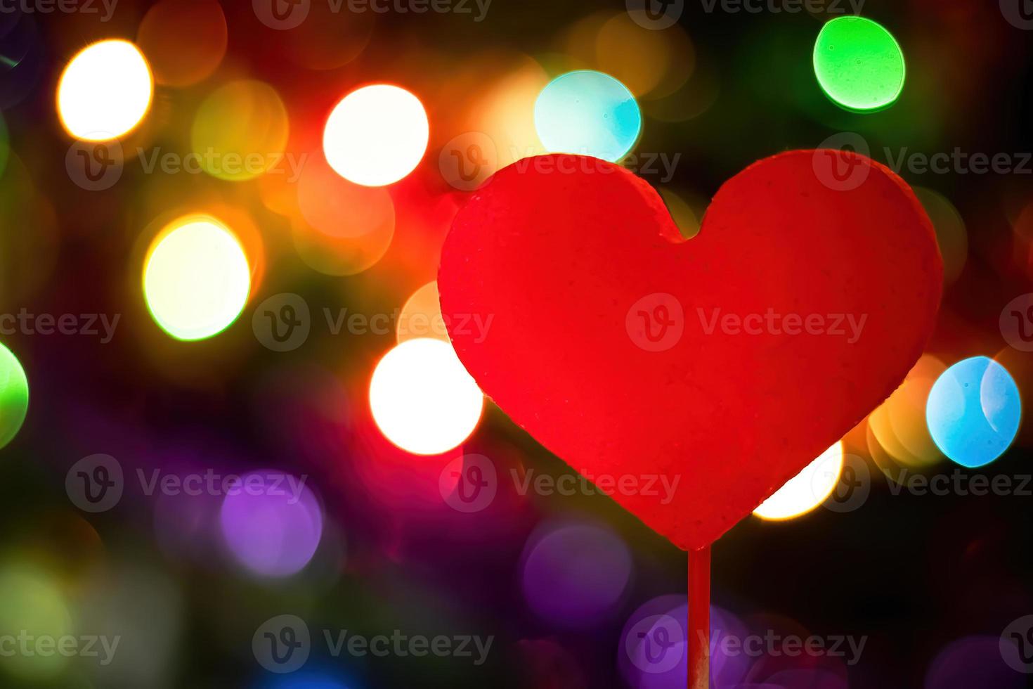 Red heart on backdrop of bright multi-colored lights. photo