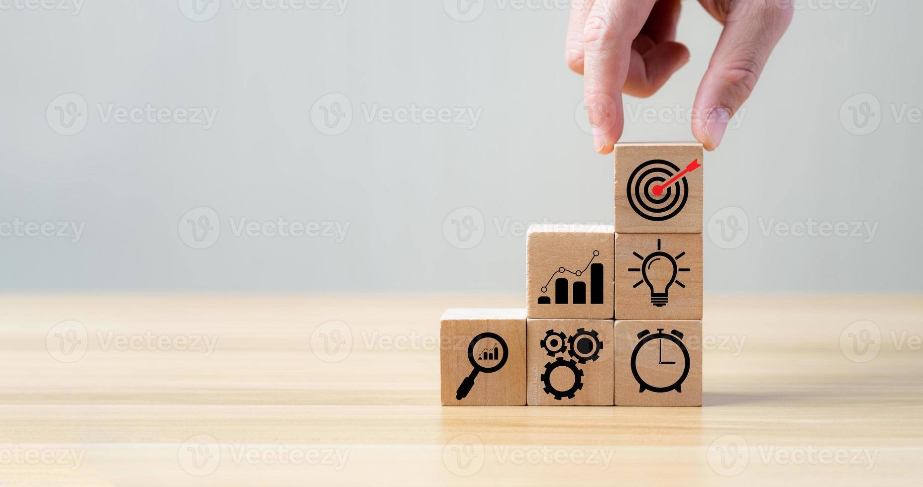 Success Concepts and Business Goals. Hand placed wooden block or selected on the table with action plan icon. Company strategy development photo