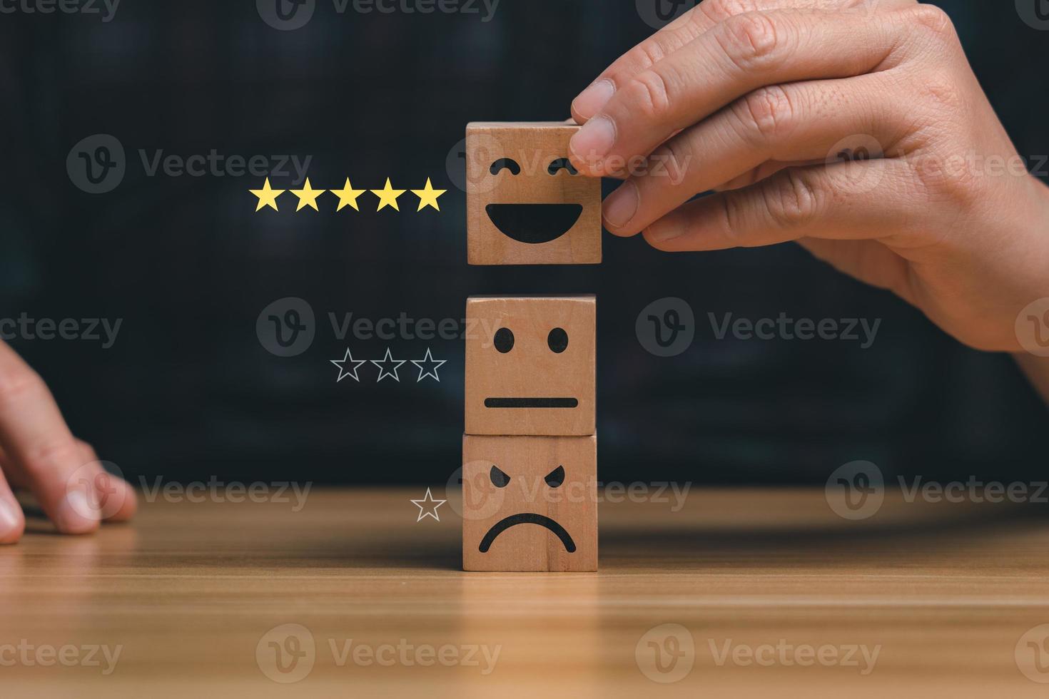 customer services best. Businessman's hand selects a smiley face on a wooden block. 5 star satisfaction, Excellent business rating experience photo