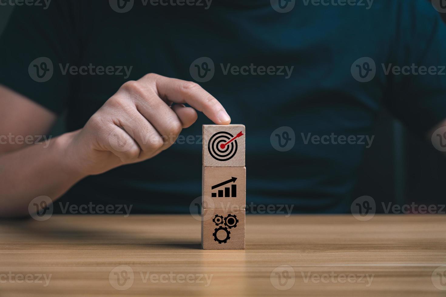 Success Concepts and Business Goals. Hand placed wooden block or selected on the table with action plan icon. Company strategy development photo