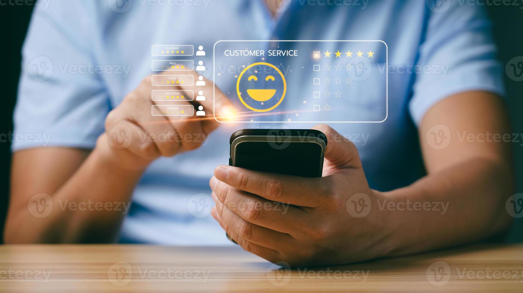 concepto de satisfacción del cliente y del consumidor. los hombres de negocios o los clientes expresan su satisfacción a través de una aplicación en la pantalla de un teléfono inteligente para elegir una calificación de 5 estrellas y un emoji de cara sonriente foto