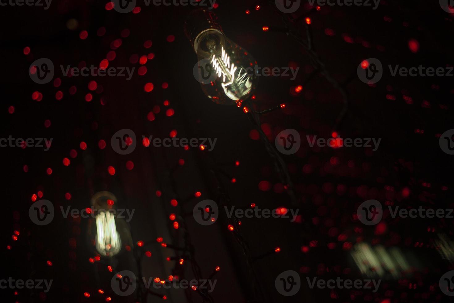 Lamps and garlands on glass. Beautiful background with lights in dark. Interior decoration details with light. photo