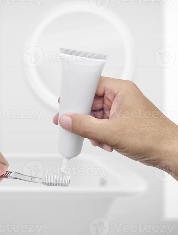 The guy squeezes toothpaste on the toothbrush photo