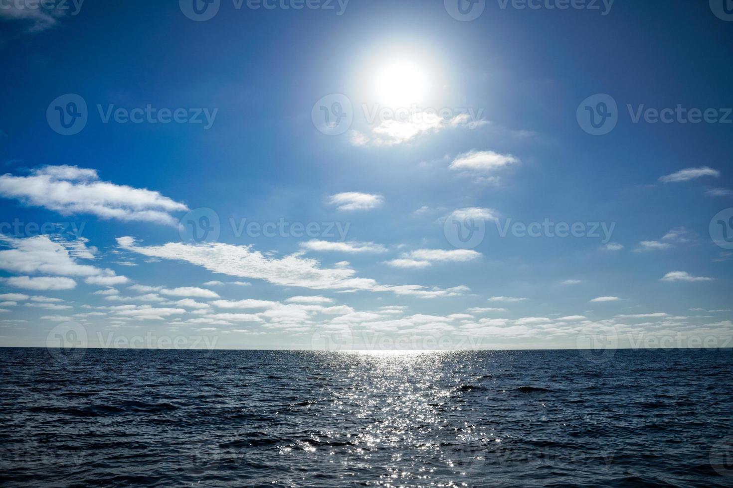 Sun behind clouds over Pacific ocean photo