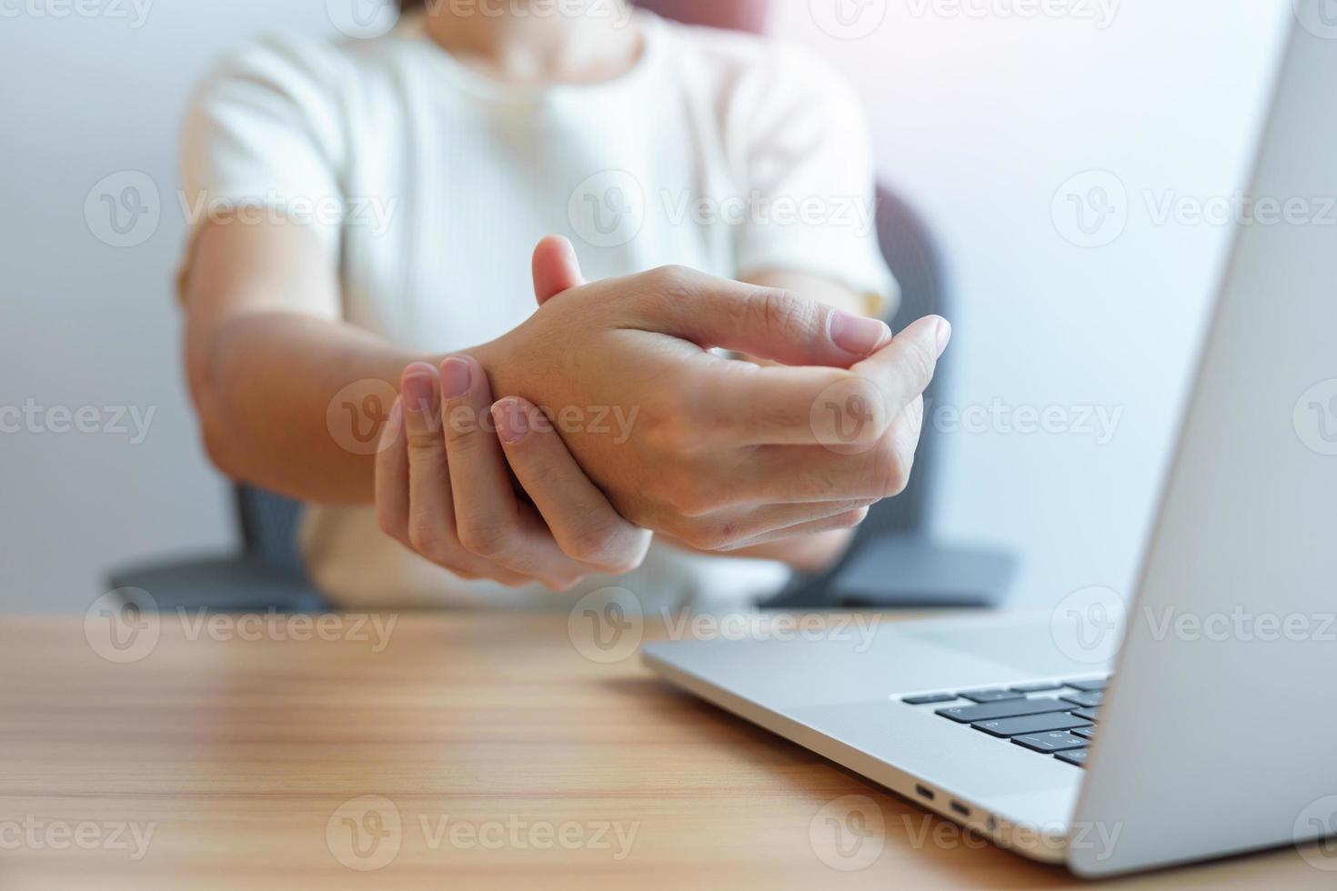 Woman having wrist pain when using laptop computer and mouse during working long time on workplace. De Quervain s tenosynovitis, rheumatism ergonomic, Carpal Tunnel Syndrome or Office syndrome concept photo