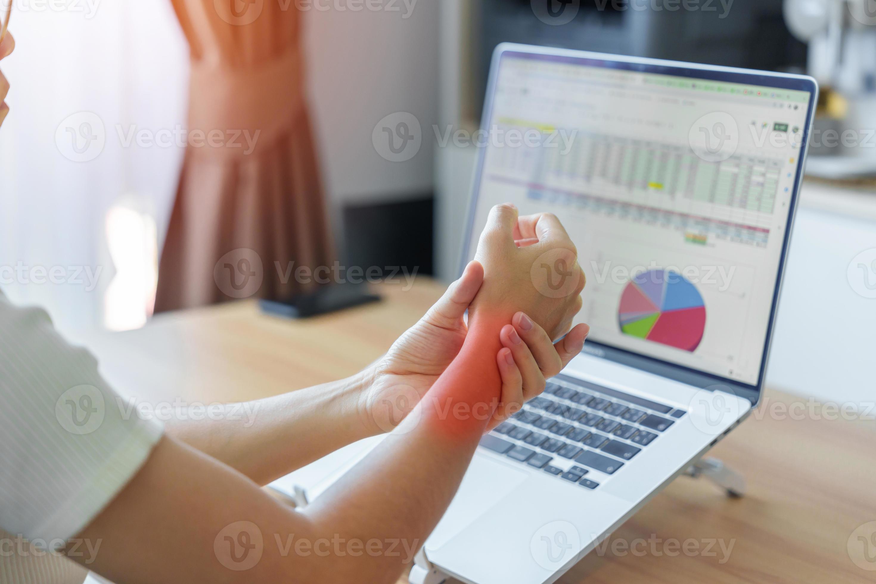 Woman having wrist pain when using laptop computer and mouse during