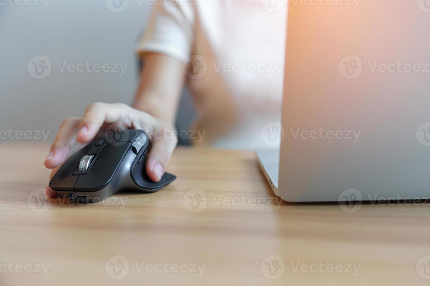 woman hand using ergonomic vertical mouse during working on Adjustable desk, prevention wrist pain. De Quervain s tenosynovitis, Intersection Symptom, Carpal Tunnel or Office syndrome concept photo