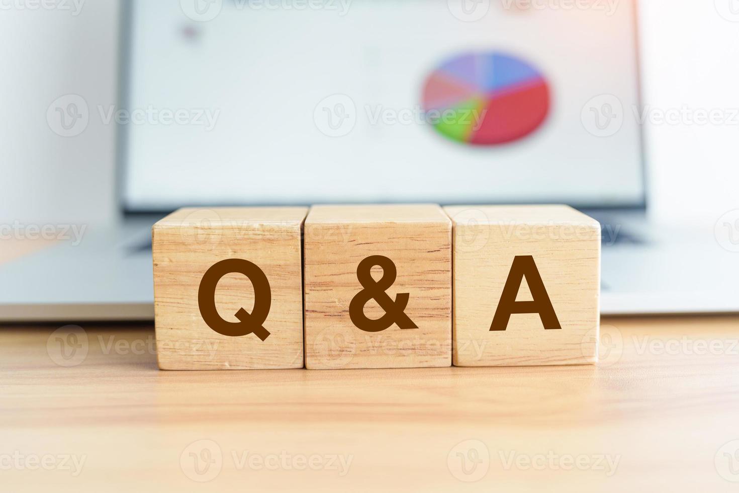 Questions and Ask wood block and laptop computer with graph background. FAQ, frequency asked questions, Answer, Q and A, Information, Communication, questionnaire and Brainstorming Concepts photo