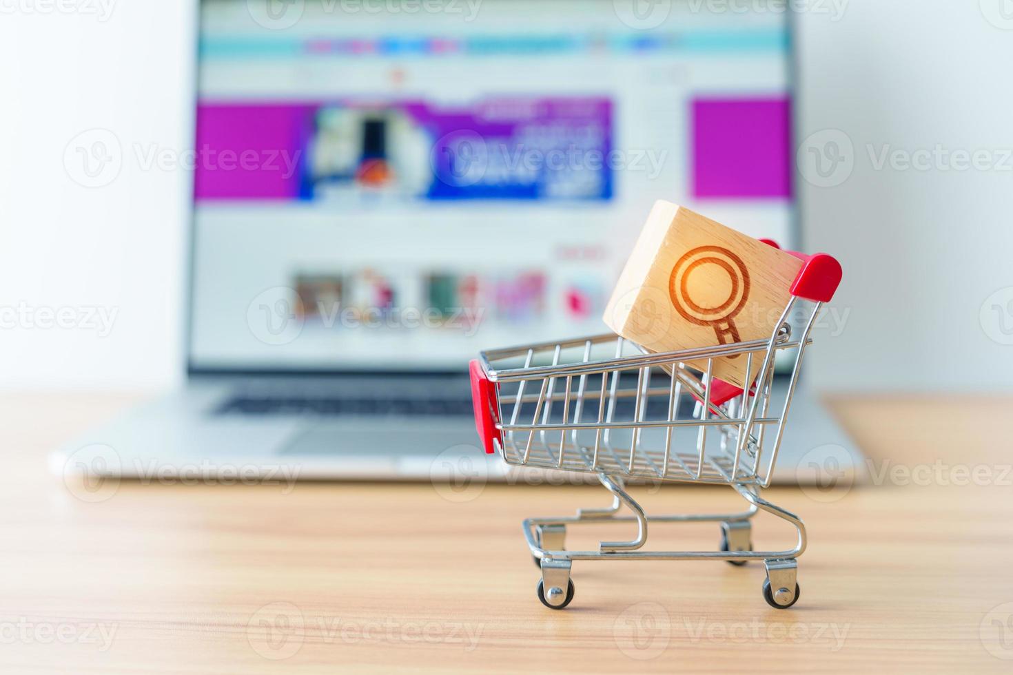 Shopping cart with Magnifying icon block and laptop computer with marketplace website, technology, ecommerce, SEO, Search Engine Optimization, Advertising, keyword and online payment concept photo