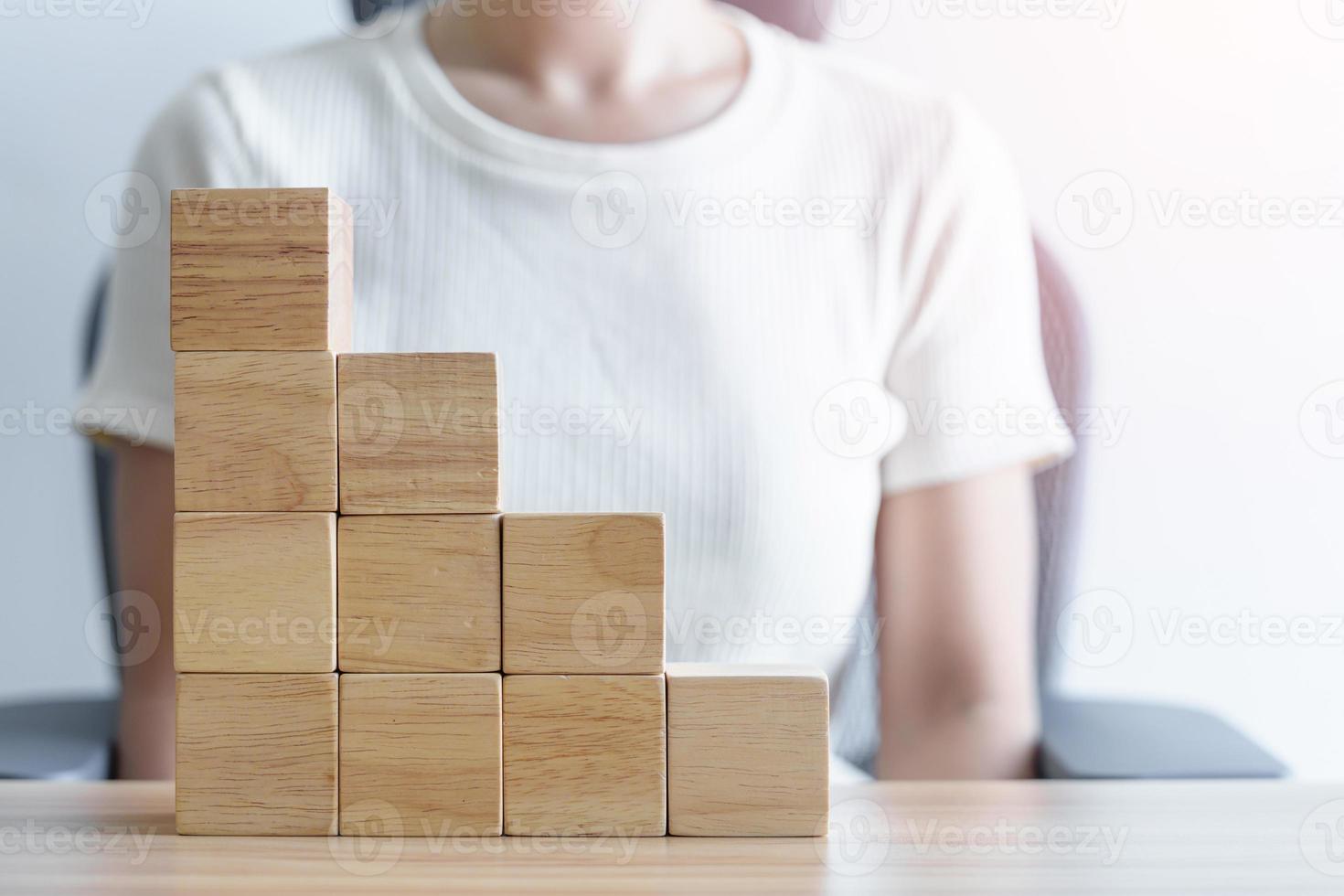 Woman hand placing wood block on the building. Leadership, Business process planning, Risk Management and strategy Concepts photo