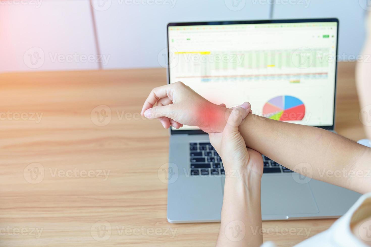 Woman having wrist pain when using laptop computer and mouse during working long time on workplace. De Quervain s tenosynovitis, rheumatism ergonomic, Carpal Tunnel Syndrome or Office syndrome concept photo