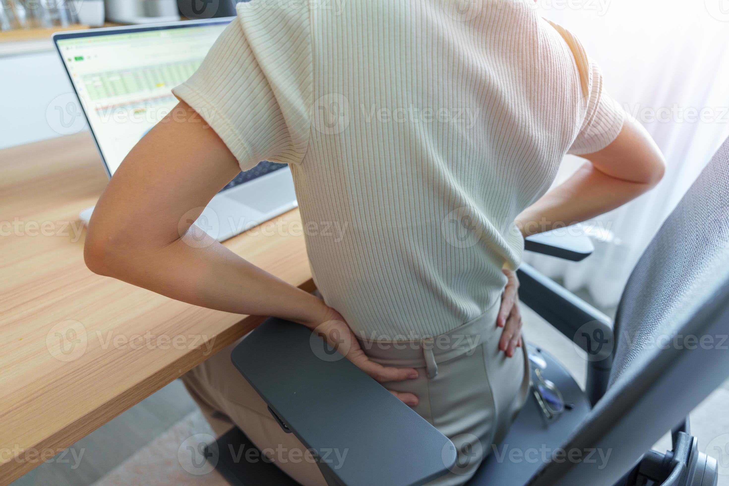Woman having back body pain during work long time on workplace. due to
