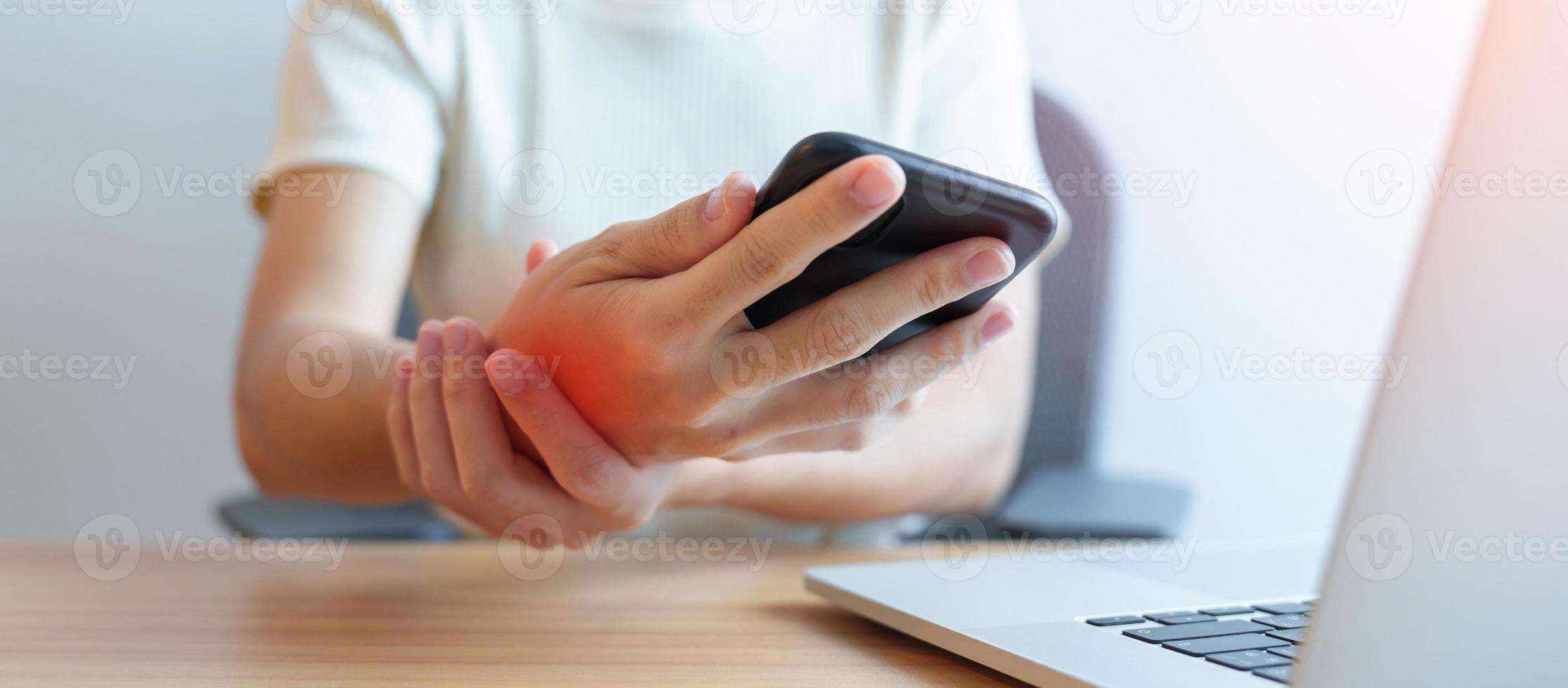 Woman having wrist pain when using mobile phone during working long time on workplace. De Quervain s tenosynovitis, ergonomic, Carpal Tunnel Syndrome or Office syndrome concept photo