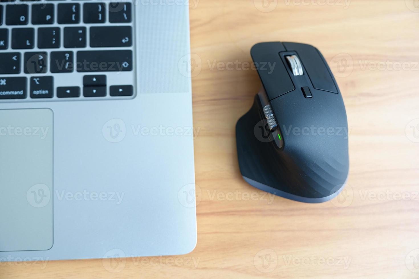 Ergonomic vertical mouse with laptop computer on adjustable desk at workplace, prevention wrist pain. De Quervain s tenosynovitis, Intersection Symptom, Carpal Tunnel or Office syndrome concept photo