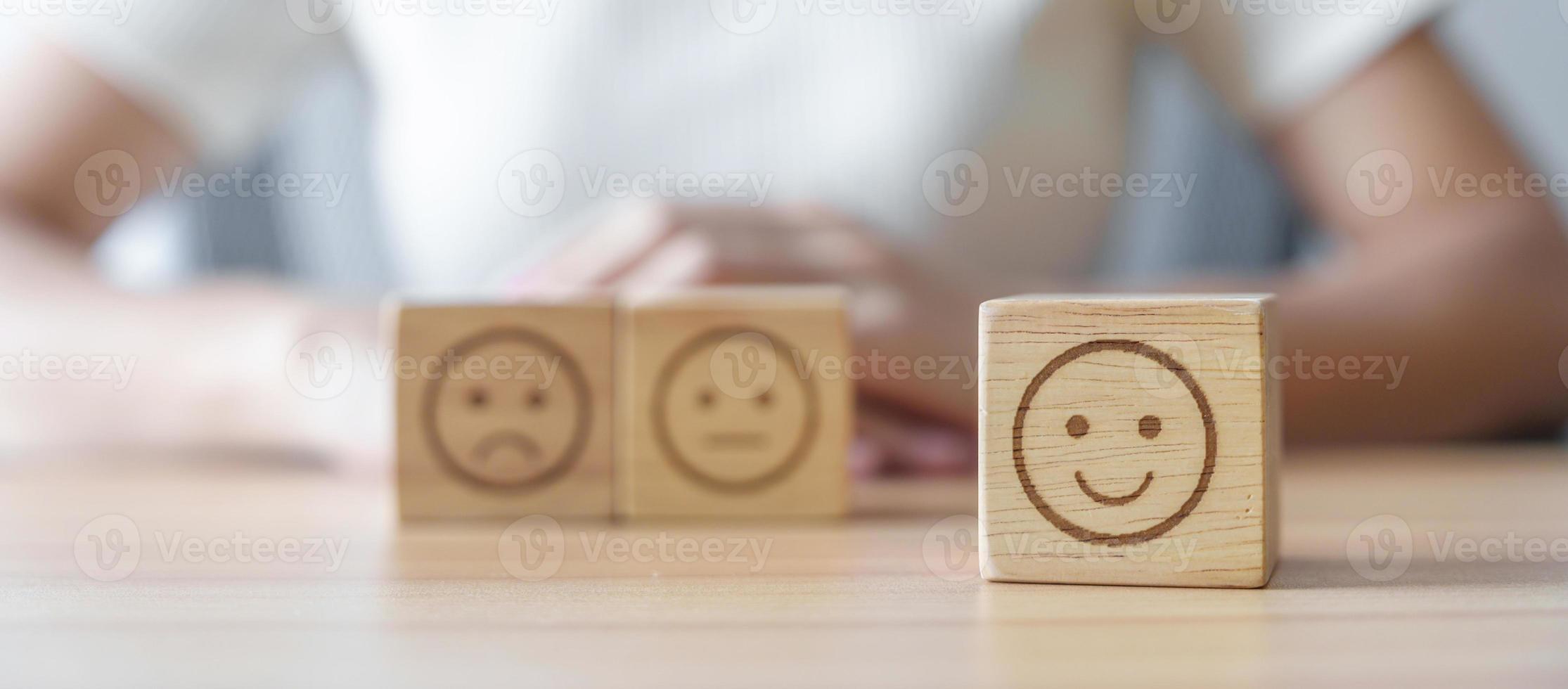 cara de sonrisa feliz eligiendo del bloque de emociones para la revisión del cliente, buena experiencia, retroalimentación positiva, satisfacción, encuesta, evaluación, estado de ánimo, concepto del día mundial de la salud mental foto