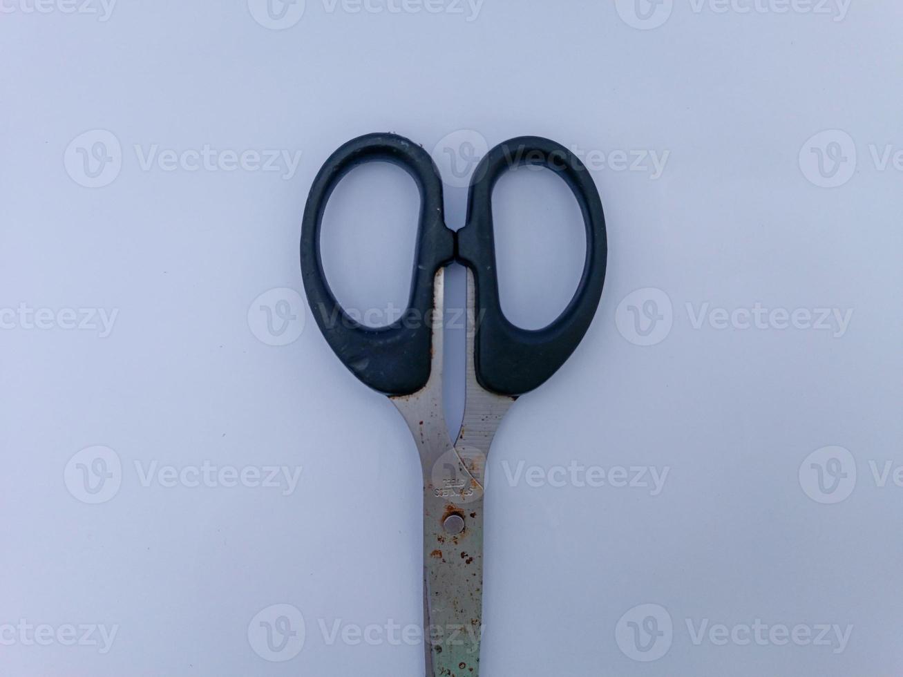 Rusty scissors with black handle photo