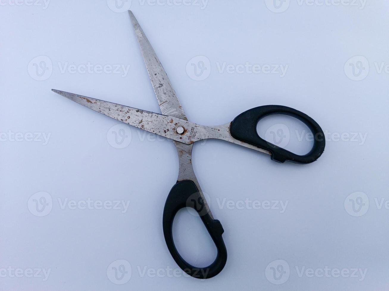 Rusty scissors with black handle photo