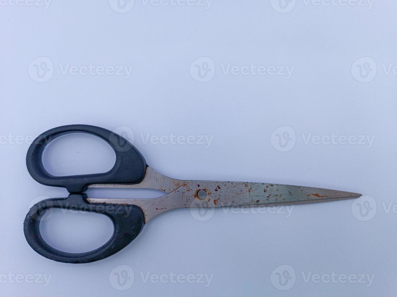 Rusty scissors with black handle photo