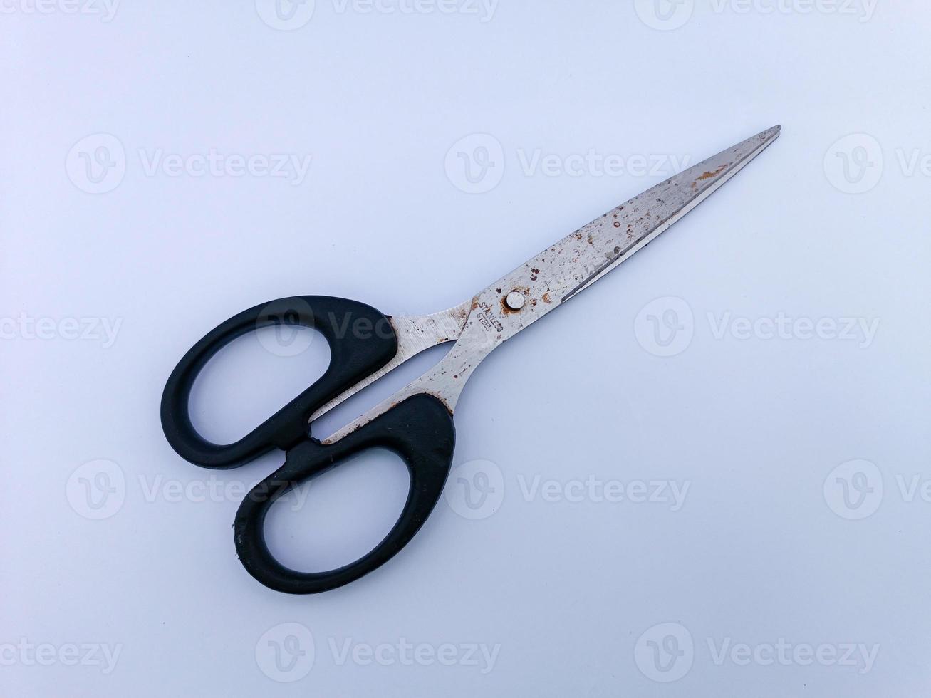 Rusty scissors with black handle photo