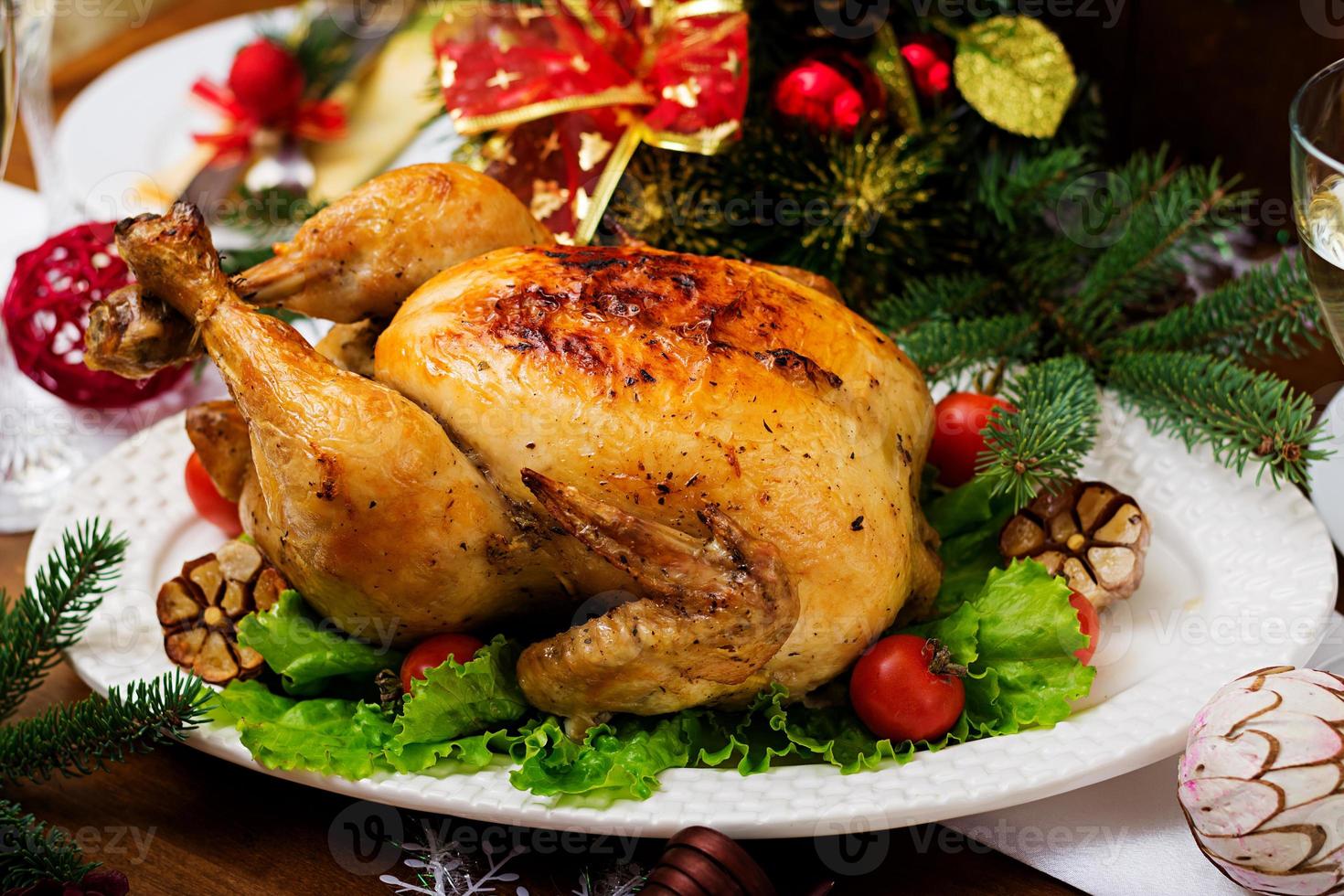 Baked turkey or chicken. The Christmas table is served with a turkey, decorated with bright tinsel and candles. Fried chicken, table. Christmas dinner. photo